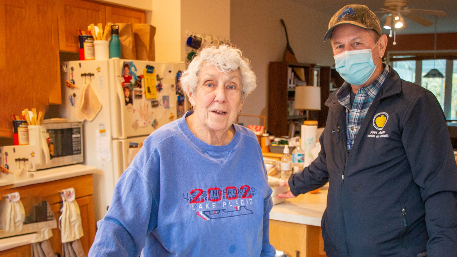 Elderly woman with Ann Arbor Meals on Wheels Volunteer in kitchen