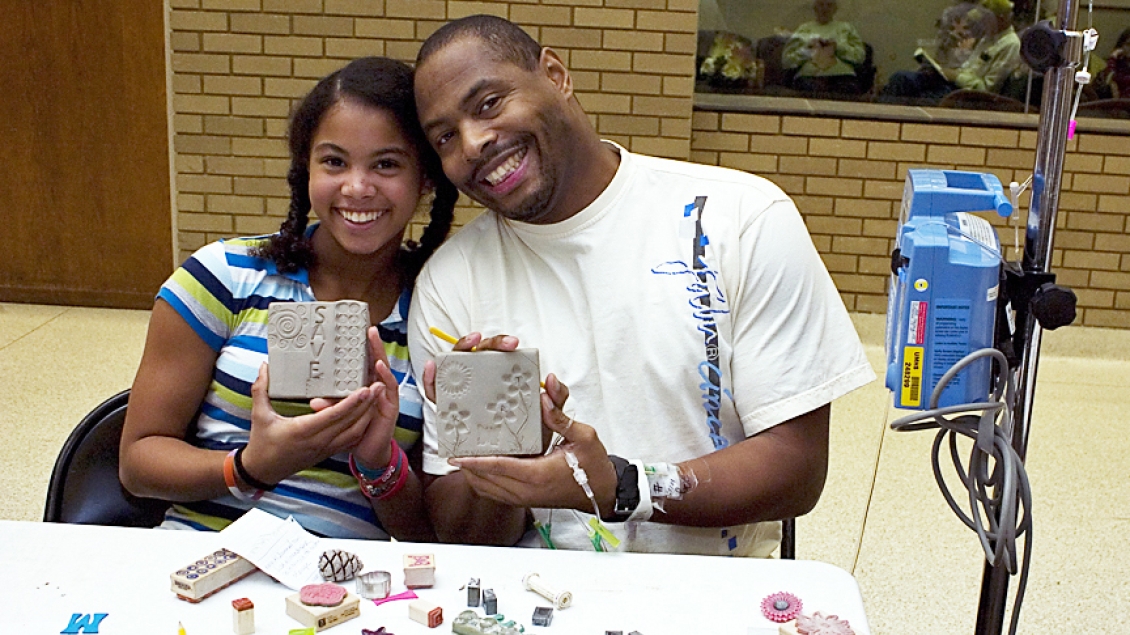 A father and daughter show off their clay artwork