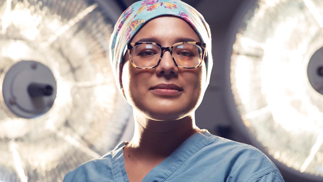 Dr. Valbuena stands in the hospital in her scrubs