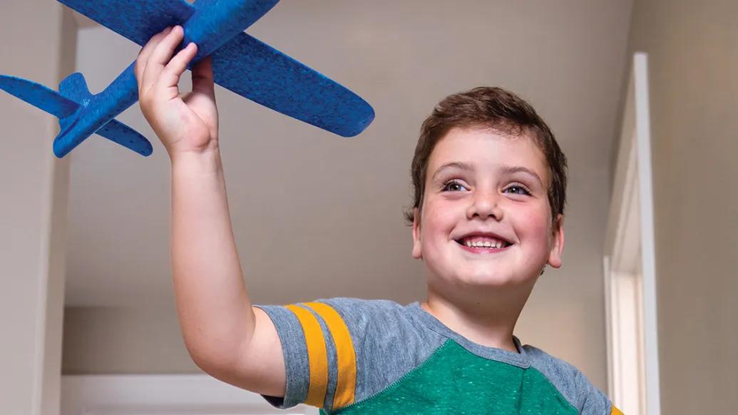 Carter plays with a toy airplane