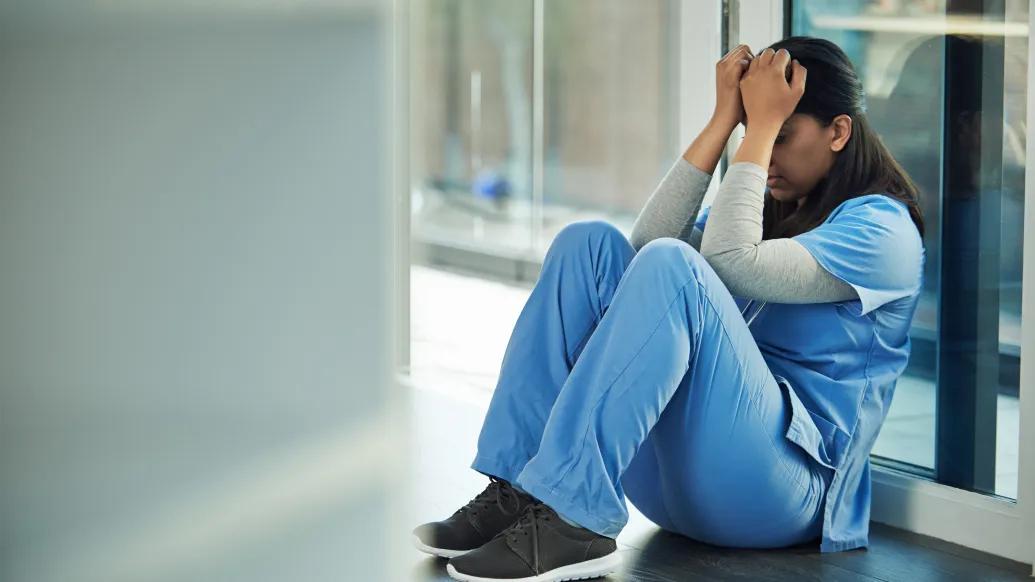 woman doctor scrubs sad ashamed lab note