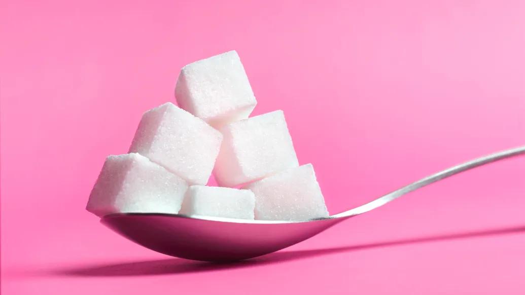 Sugar cubes on pink background