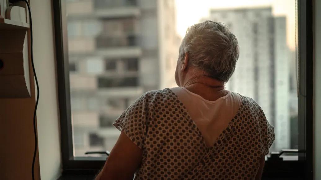 man patient looking out window