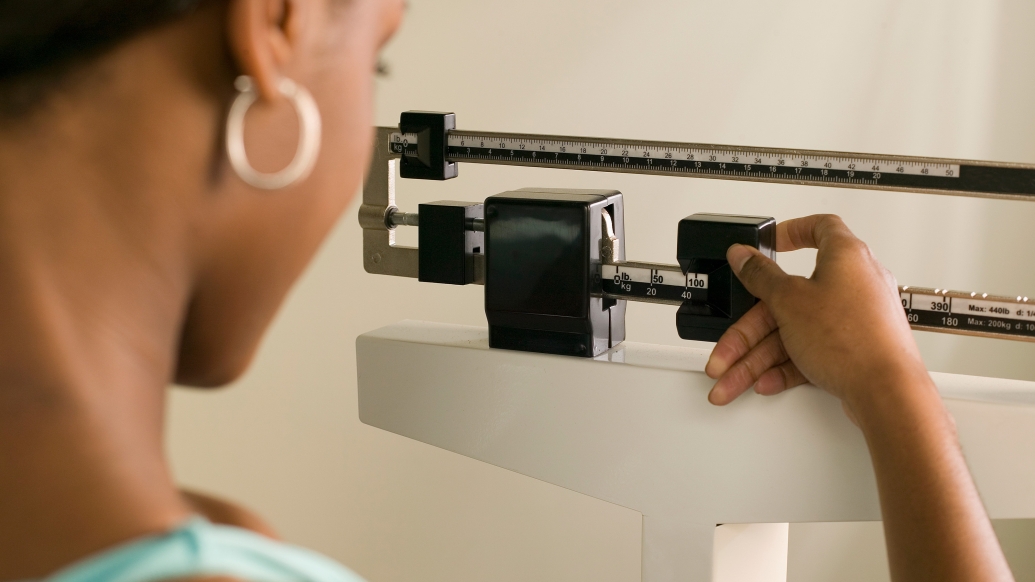 Woman weighing herself and a scale measurement