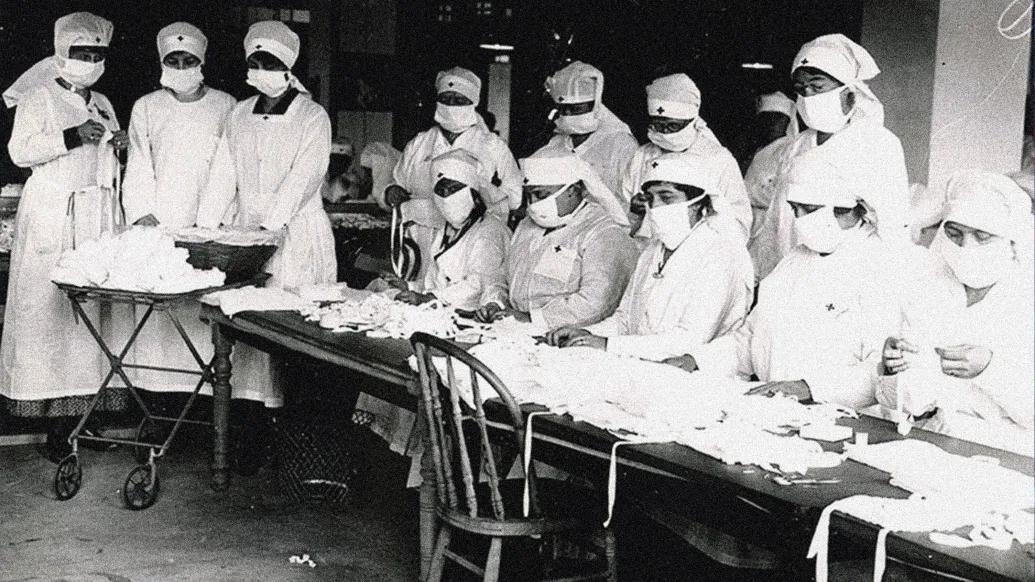 nurses from 1918 wearing masks in hospitals standing together black and white photo