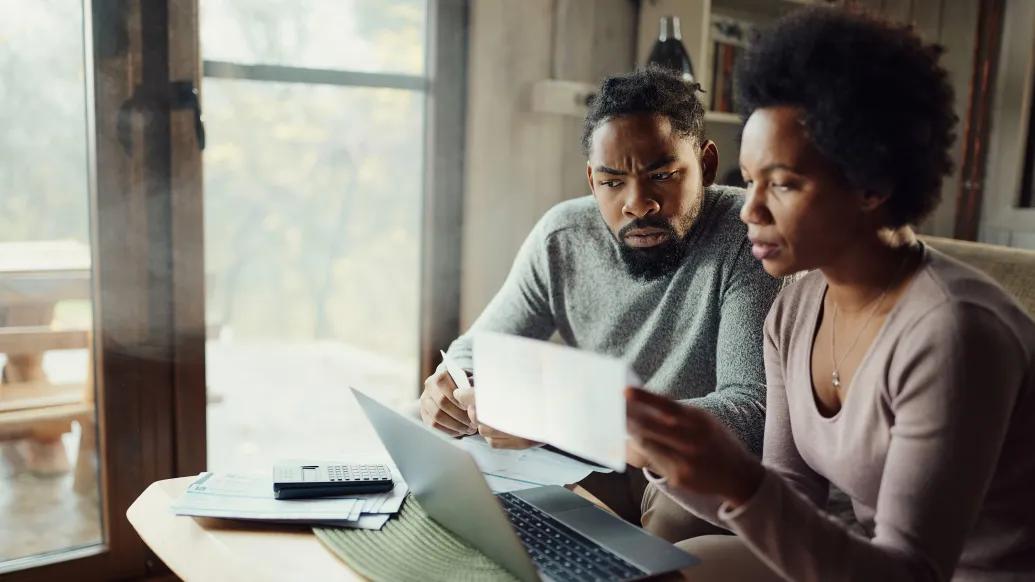 couple looking at paper work concerned at home
