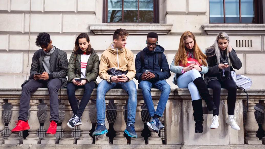 Teenagers Sitting Wall Phones Building