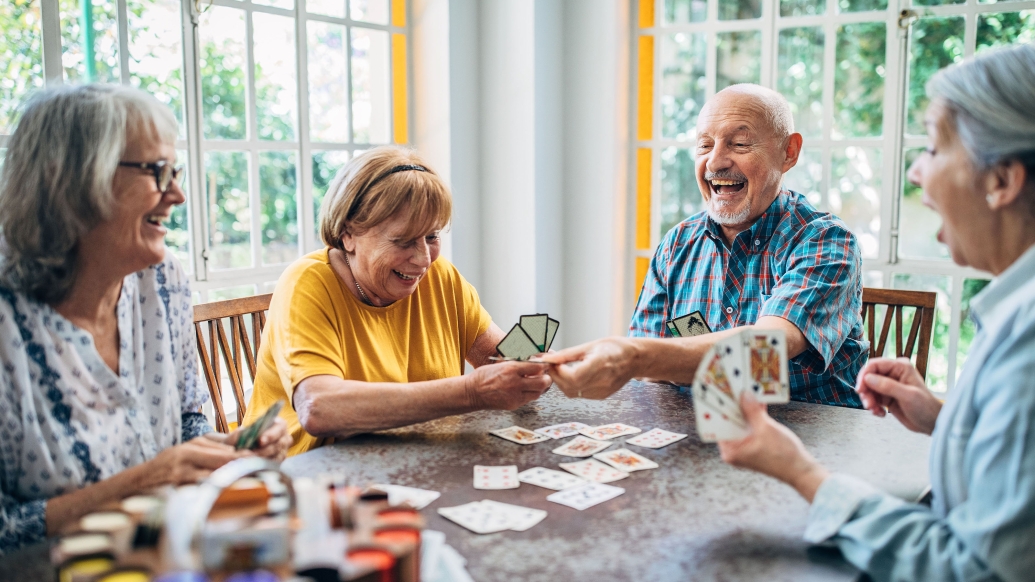 older adults playing cards at table