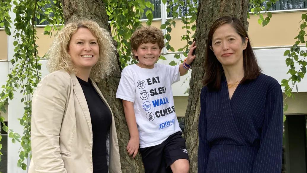 mom child and doctor smiling by tree