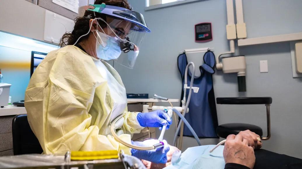 A dentist operates on a patient at Exalta Health in Grand Rapids