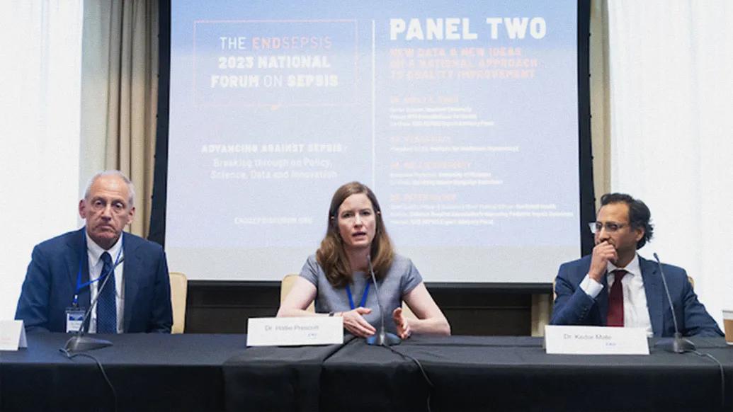 Hallie Prescott talking while sitting at a panel table with two individuals.