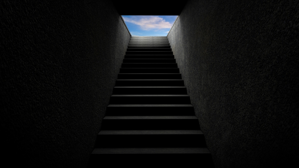 Dark staircase leading to blue sky above