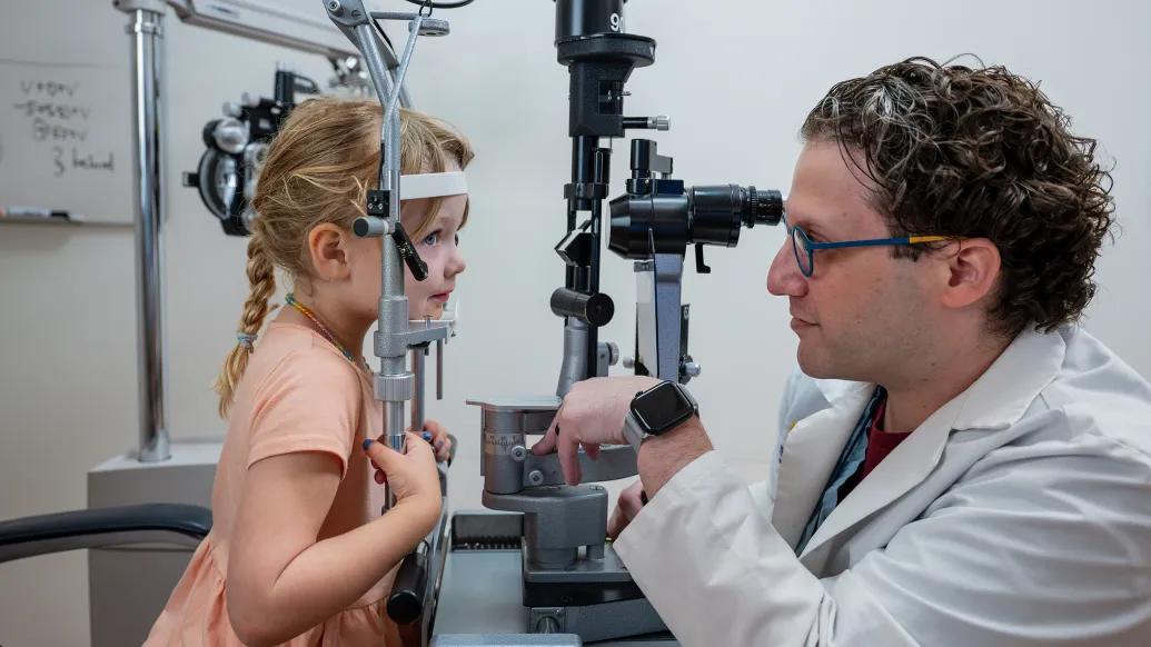 Ophthalmologist Adam Jacobson, M.D., examines a young patient.