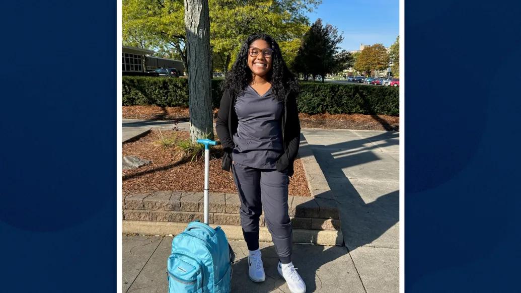 young woman standing on her own smiling outside
