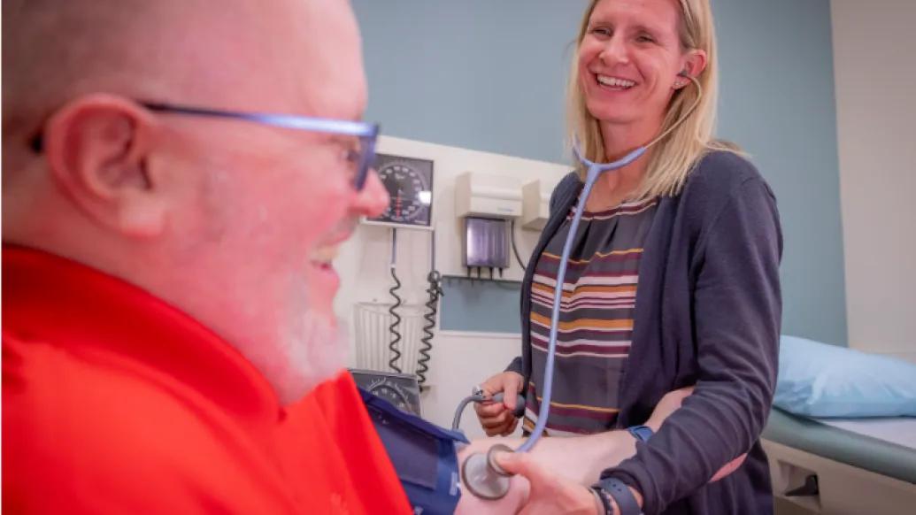 Samantha Fink, administrative manager at U-M Health Cardiovascular Medicine at Domino's Farms, takes a person's blood pressure.