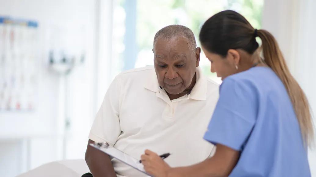 patient looking at paper with provider in scrubs blue in clinic 