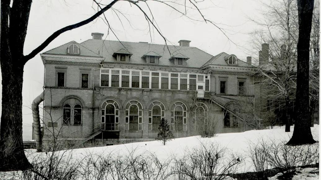 Black and white photo of the Palmer Ward for pediatrics that was part of the old University Hospital campus before "Old Main" was built in the 1930s. It's a 3-story building with large arched windows in front.