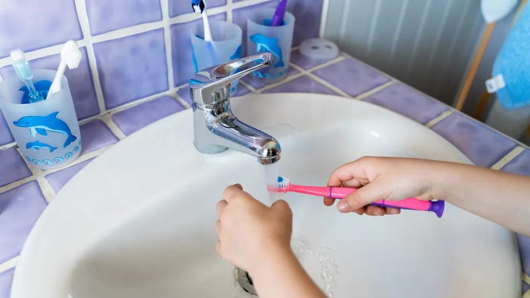sink brushing pink toothbrush