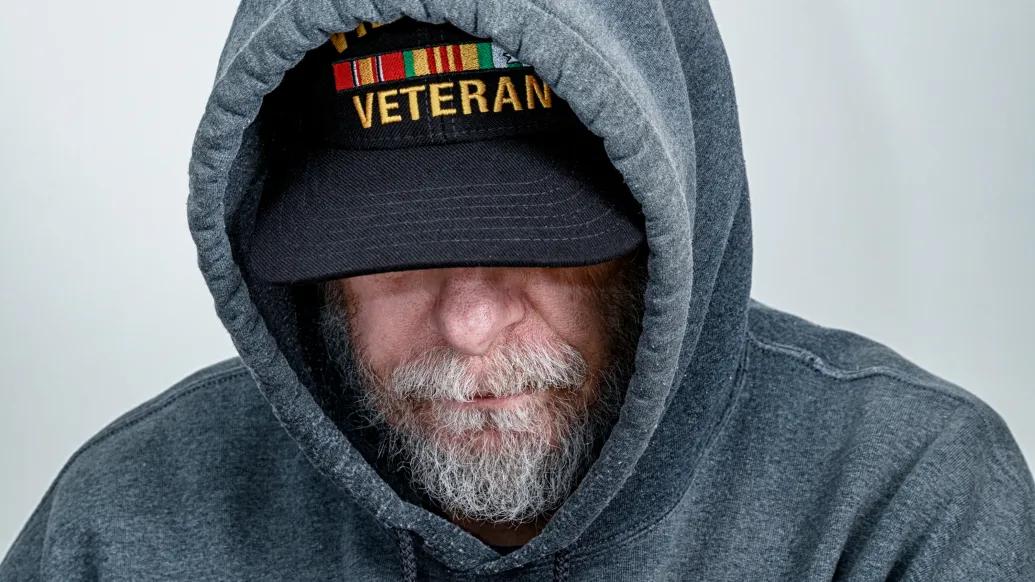 man in veteran hat with hooded sweatshirt
