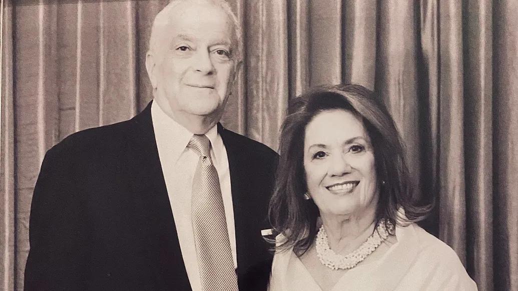 Smiling portrait of Philip and Myrna Fischer standing together in a formal setting.