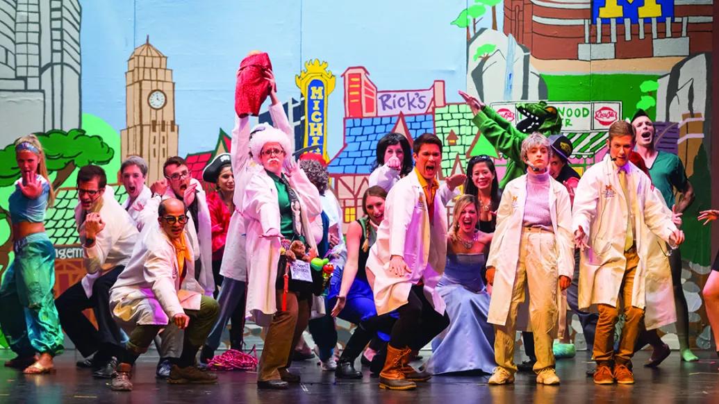 Students on stage in costume perform a song during the 2015 Galens Smoker spoof show.