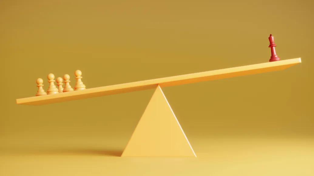 chess pieces yellow background one red piece on right and yellow on left weighing the balance beam down