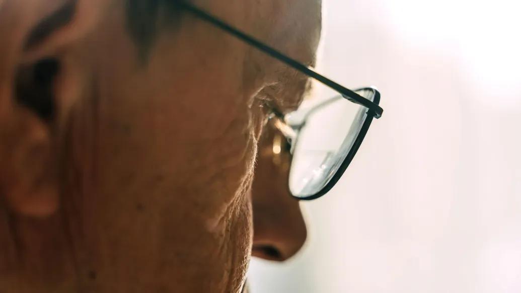close up of older mans eye through glasses