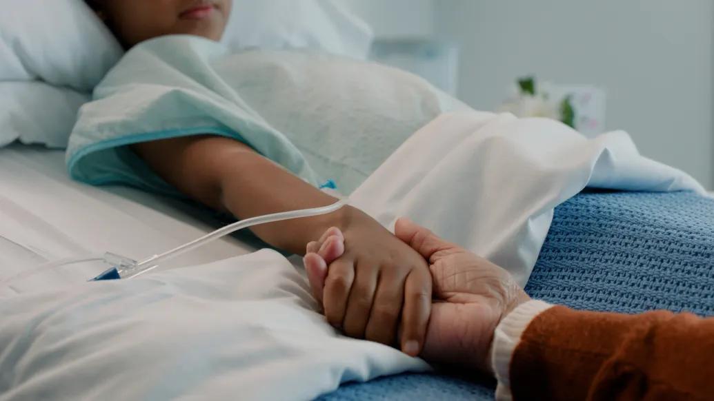 hand holding in bed child hopsital