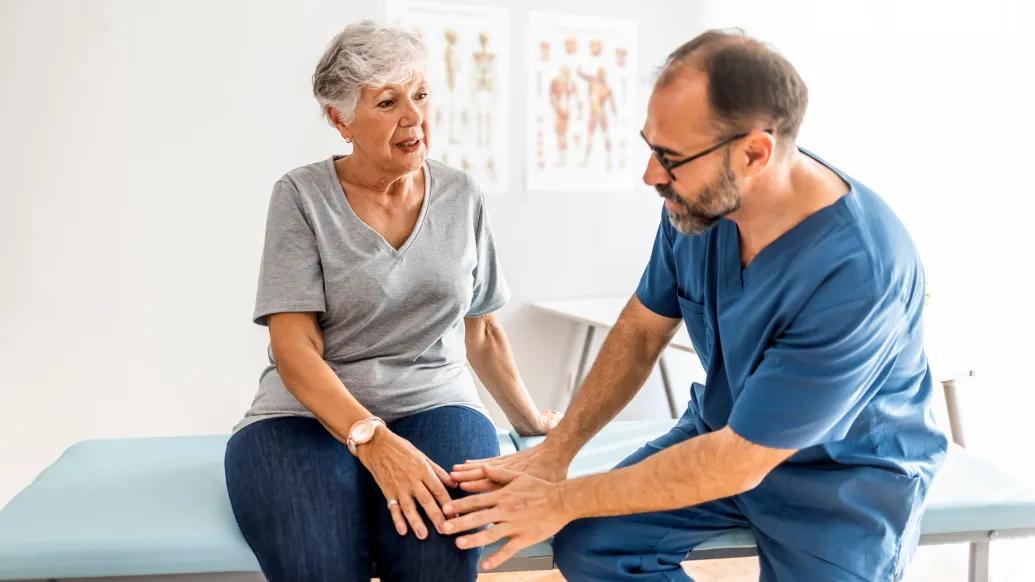woman on table with doctor talking to her