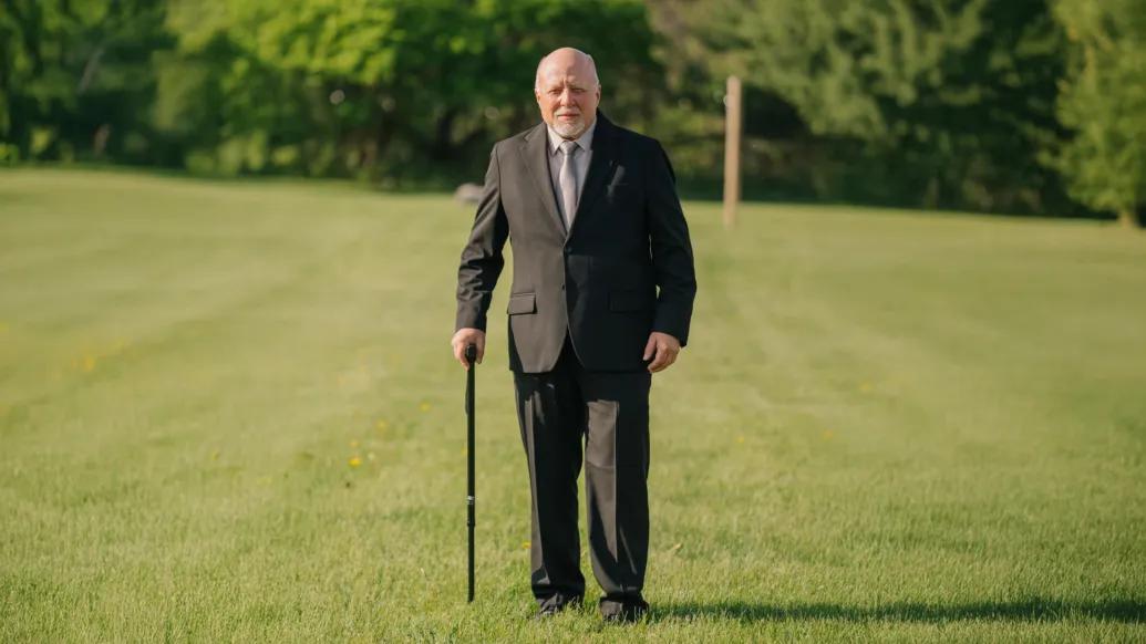 man standing with cane with suit on in black