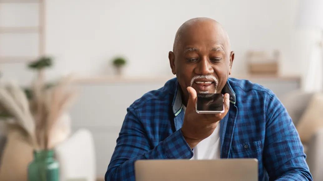man speaking on phone while on computer