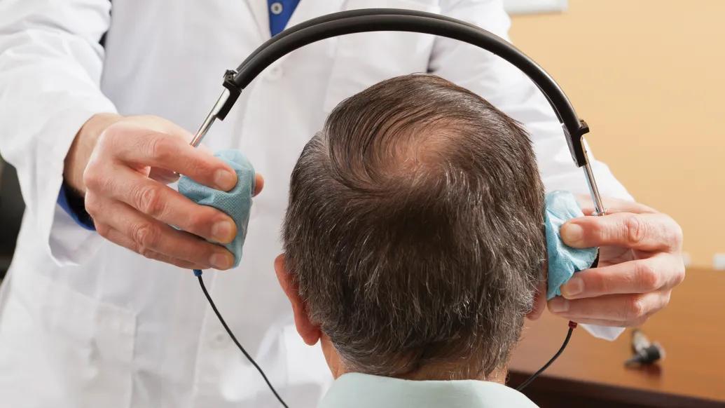 up close head with headphones going on patients head seeing from back of head