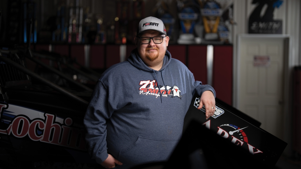 man standing alone smiling with heat and navy blue sweatshirt