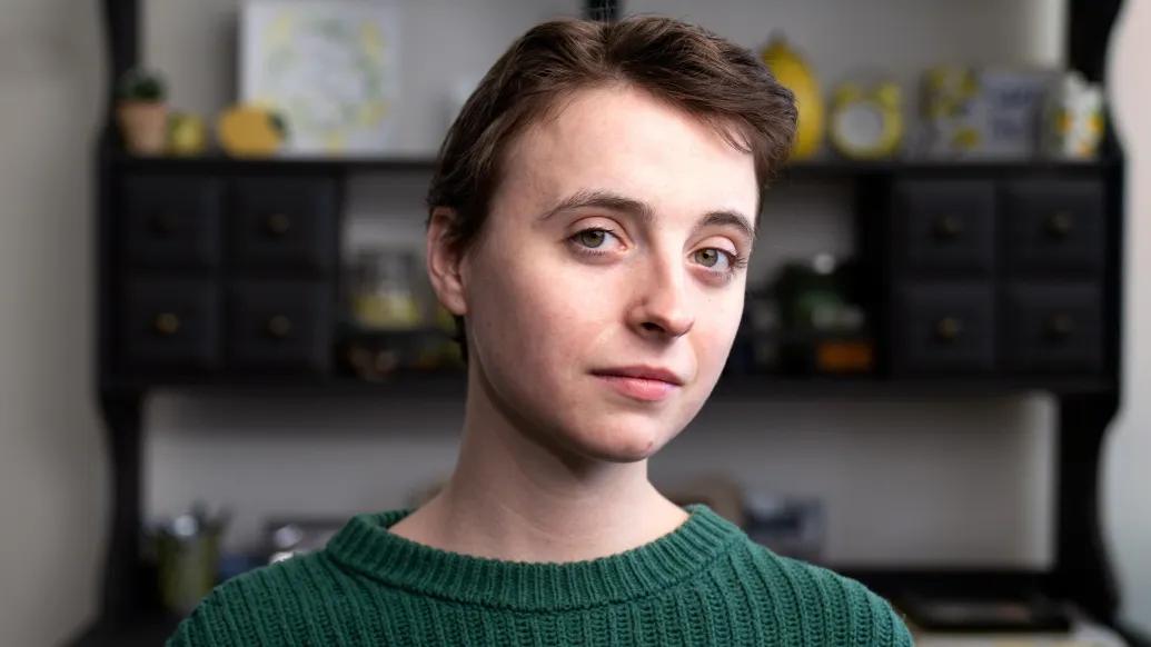 women close up of face semi-smiling in green shirt short hair brown