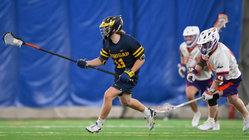 lacrosse player UM playing on field in action
