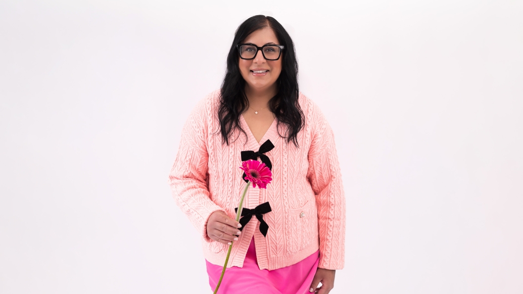 woman wearing all pink and holding pink flower