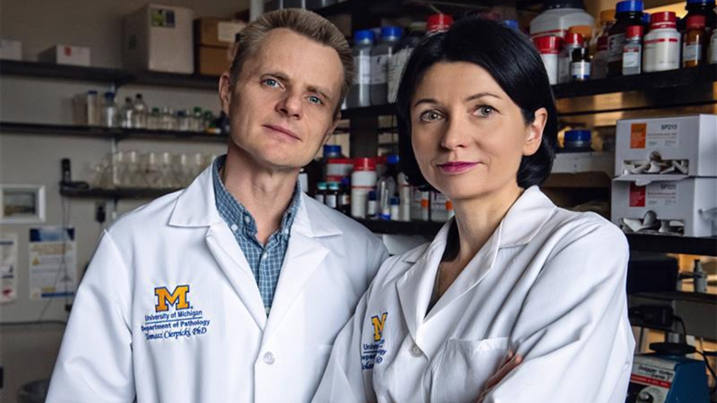 two researchers posing white coats looking at camera