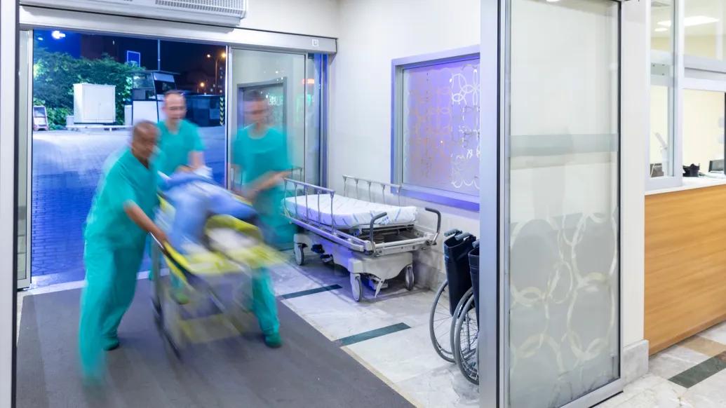blur of hospital staff moving patient in on stretcher 