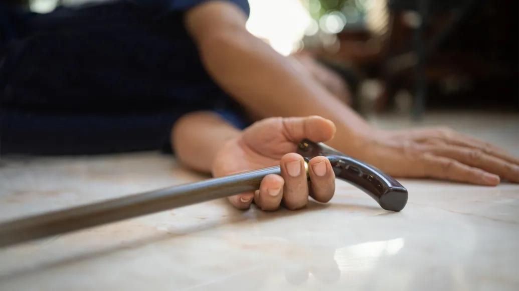 close up of hands on floor with cane