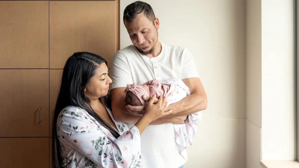 parents holding baby in hospital