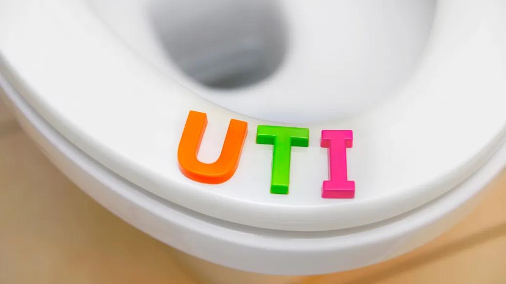 UTI written out with block letters on a toilet seat white