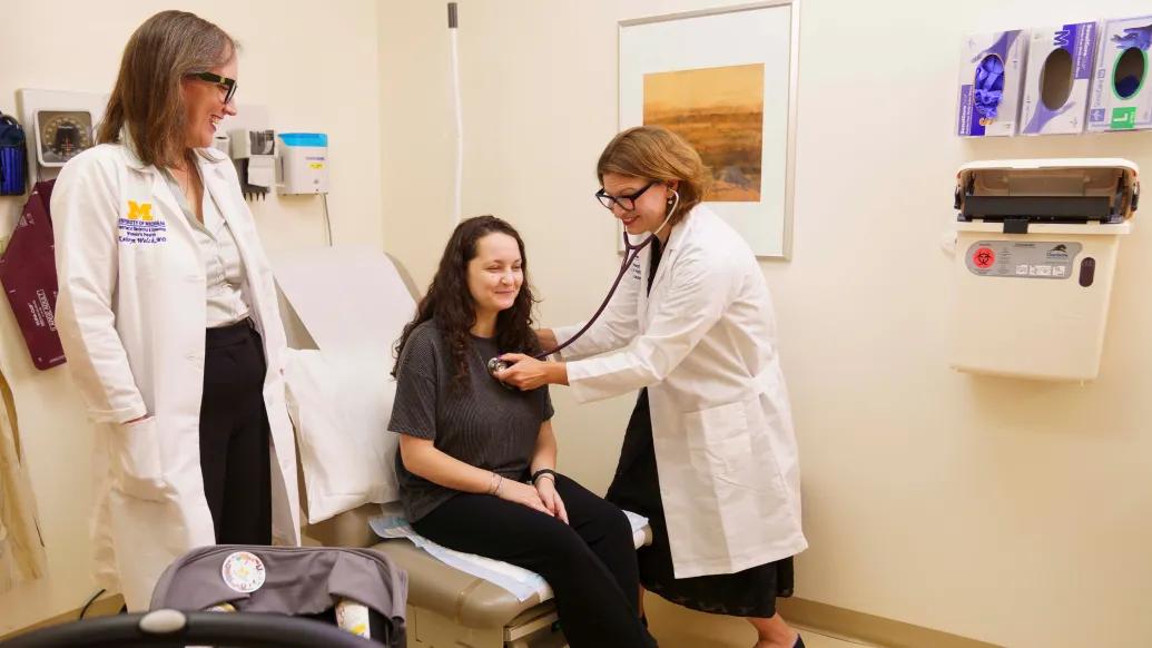 two doctors with patient listening to heart