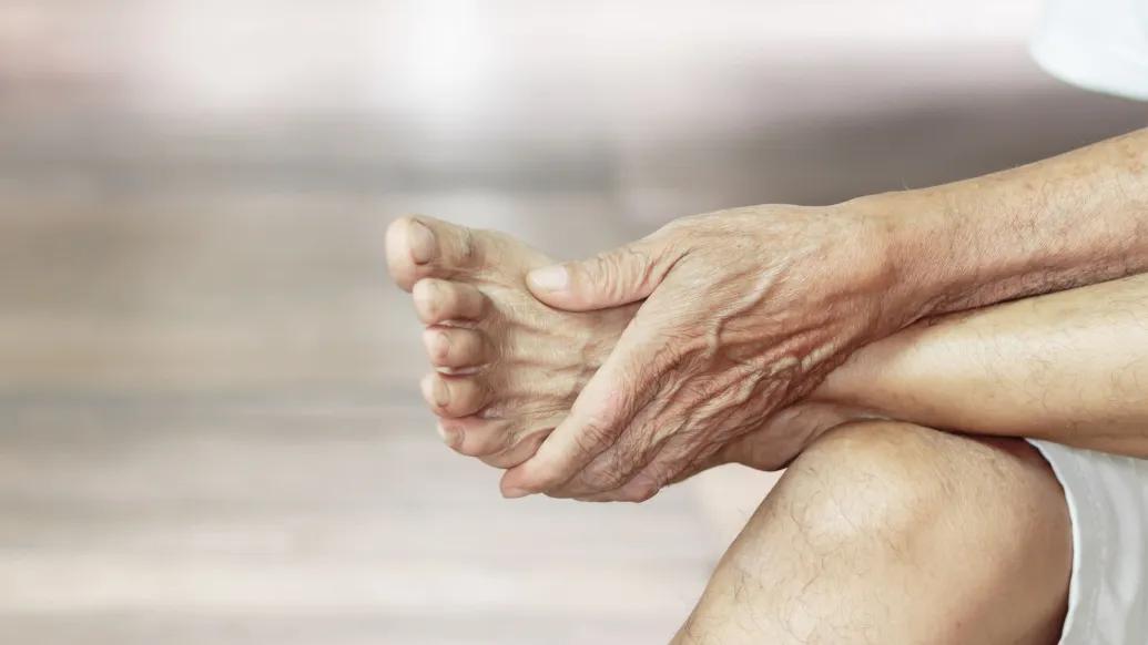 Person rubbing foot while sitting