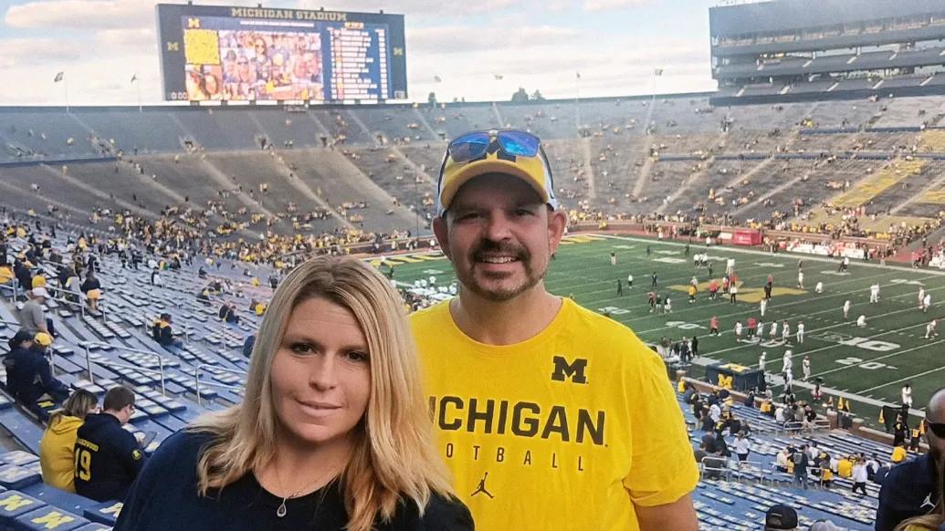 couple smiling at michigan game