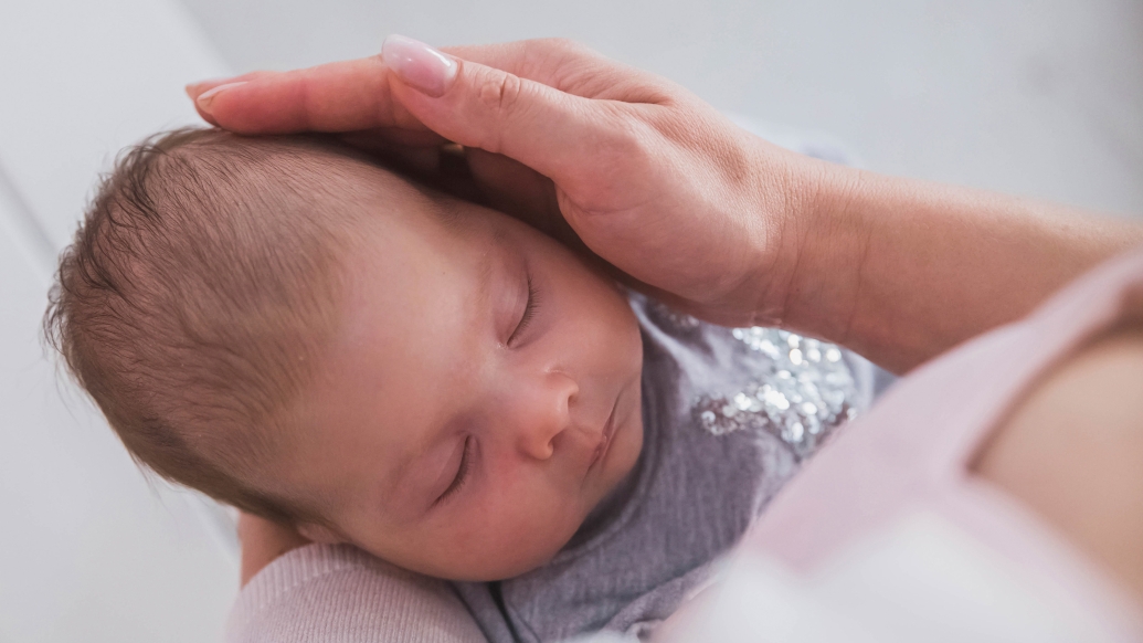 newborn close up in adult's arms