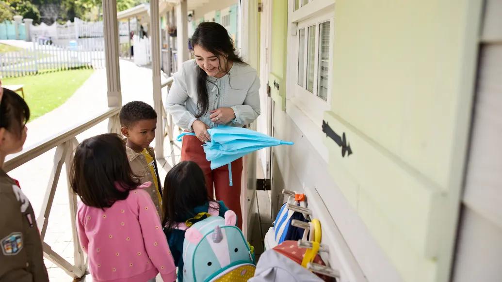 children with adult at daycare outside on a porch
