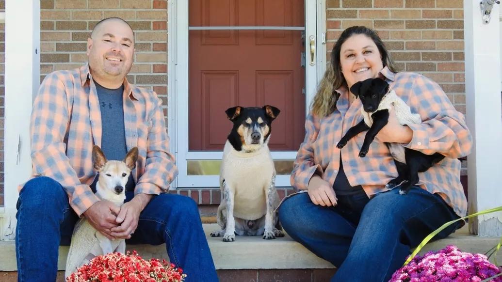 couple with 3 dogs on porch smiling