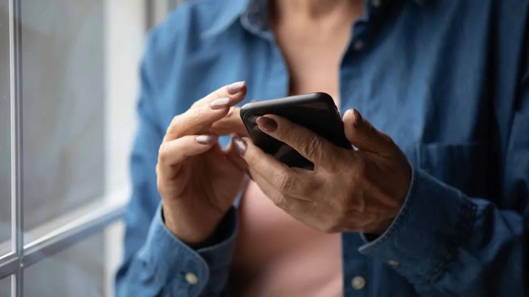 An older adult's hands holding a smartphone