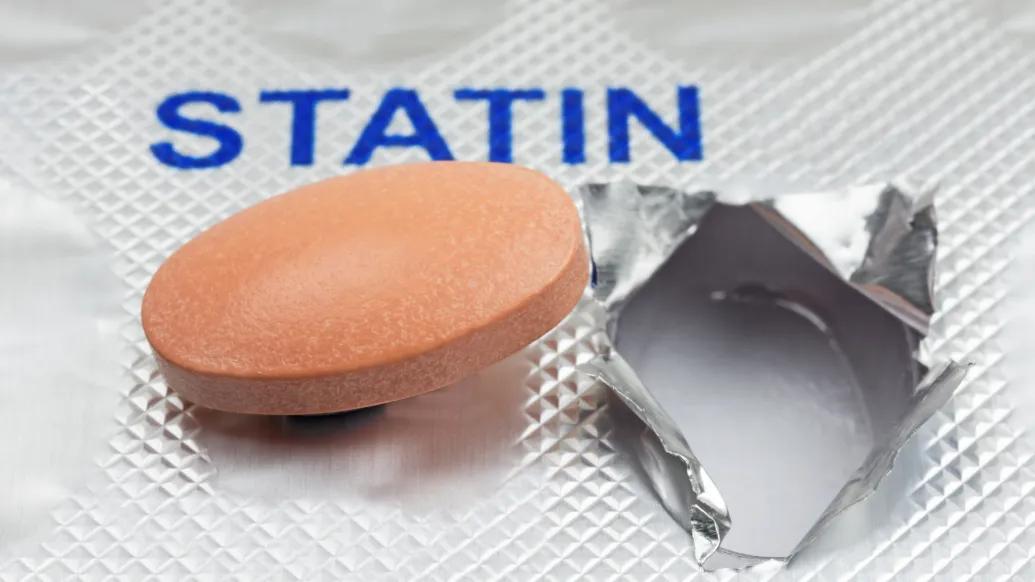 word statin in capital letters blue and pill out of silver case