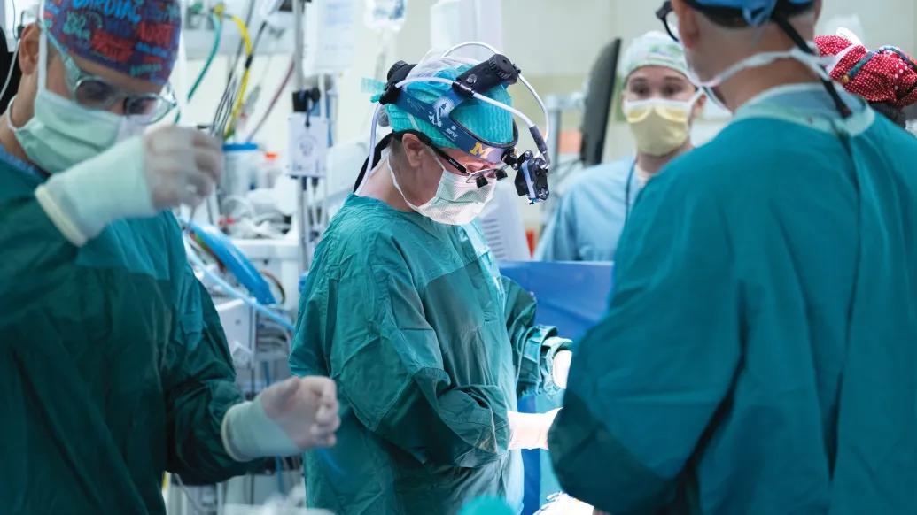 surgeon and surgical team set up in OR with teal gear on and masks